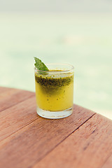 Image showing glass of fresh juice or cocktail on table at beach