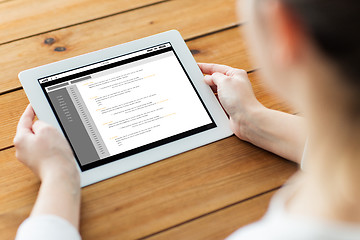 Image showing close up of woman with tablet pc on wooden table