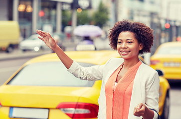 Image showing happy african woman catching taxi