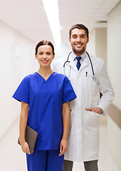 Image showing smiling doctor in white coat and nurse at hospital