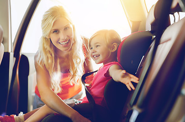 Image showing happy mother fastening child with car seat belt