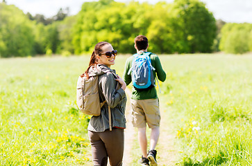 Image showing happy couple with backpacks hiking outdoors