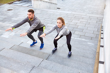 Image showing couple doing squats on city street stairs