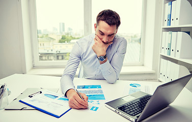 Image showing stressed businessman with papers in office