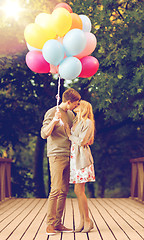 Image showing couple with colorful balloons kissing in the park