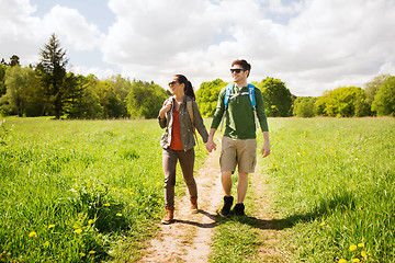 Image showing happy couple with backpacks hiking outdoors