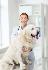 Image showing happy doctor with retriever dog at vet clinic