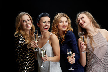 Image showing happy women with champagne glasses over black