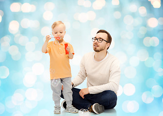 Image showing father with son blowing bubbles and having fun