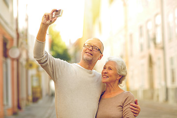 Image showing senior couple photographing on city street