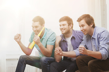 Image showing happy male friends with vuvuzela watching sports