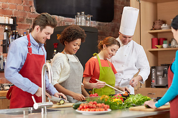 Image showing happy friends and chef cook cooking in kitchen