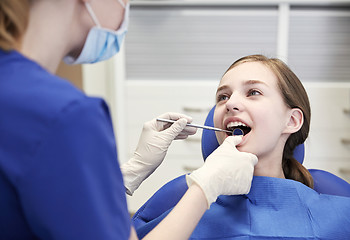 Image showing female dentist checking patient girl teeth