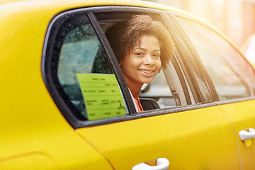 Image showing happy african american woman driving in taxi