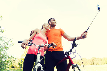 Image showing couple with bicycle and smartphone selfie stick