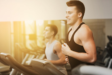 Image showing smiling men exercising on treadmill in gym