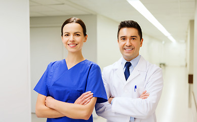 Image showing smiling doctor in white coat and nurse at hospital