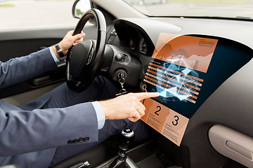 Image showing man driving car and pointing to on-board computer