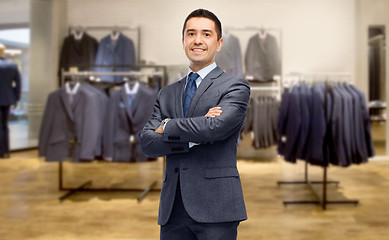 Image showing happy businessman in suit over clothing store