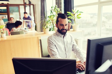 Image showing happy creative male office worker with computer