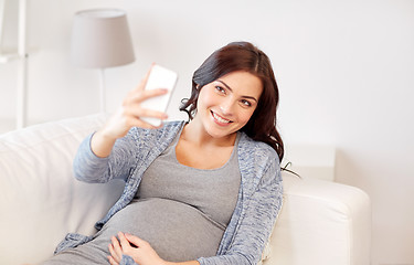 Image showing pregnant woman taking smartphone selfie at home