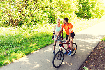 Image showing happy couple with rollerblades and bicycle riding