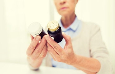 Image showing close up of senior woman with medicine jars