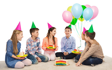 Image showing happy children in party hats with birthday cake