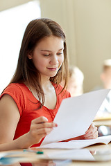 Image showing happy student girl with test paper at school