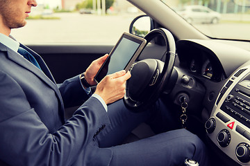 Image showing close up of young man with tablet pc driving car