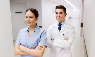 Image showing smiling doctor in white coat and nurse at hospital