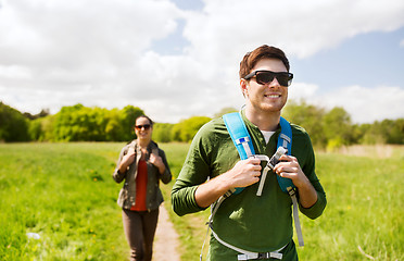 Image showing happy couple with backpacks hiking outdoors