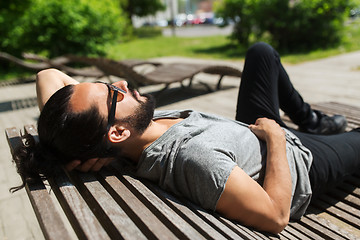 Image showing happy man lying on street bench or sun bed 