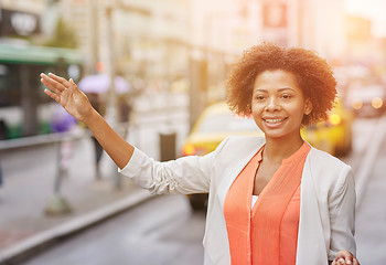 Image showing happy african woman catching taxi