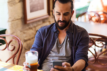 Image showing man with smartphone drinking beer at bar or pub