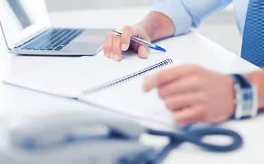 Image showing businessman writing in notebook