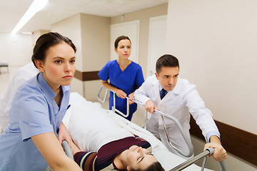 Image showing medics with woman on hospital gurney at emergency