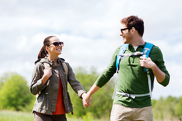 Image showing happy couple with backpacks hiking outdoors