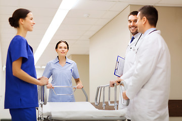 Image showing group of happy doctors with gurney at hospital