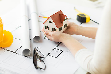 Image showing close up of hands with house model above blueprint