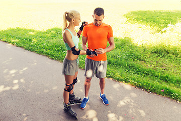 Image showing happy couple with roller skates riding outdoors