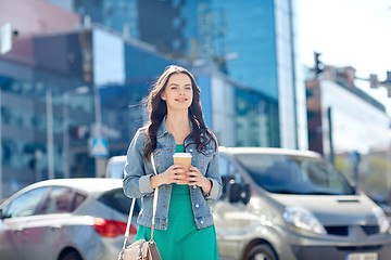 Image showing happy young woman drinking coffee on city street