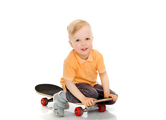 Image showing happy little boy sitting on skateboard