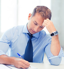 Image showing businessman writing in notebook