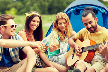 Image showing happy friends with drinks and guitar at camping