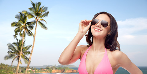 Image showing happy woman in sunglasses and bikini on beach