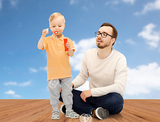 Image showing father with son blowing bubbles and having fun