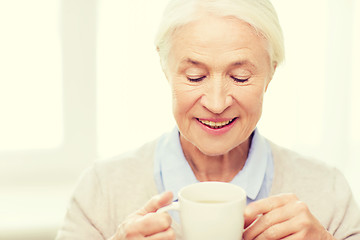 Image showing happy senior woman with cup of tea or coffee