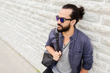 Image showing man with backpack standing at city street wall