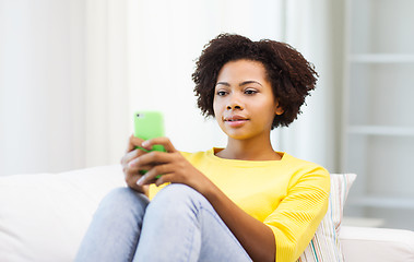 Image showing happy african woman with smartphone at home